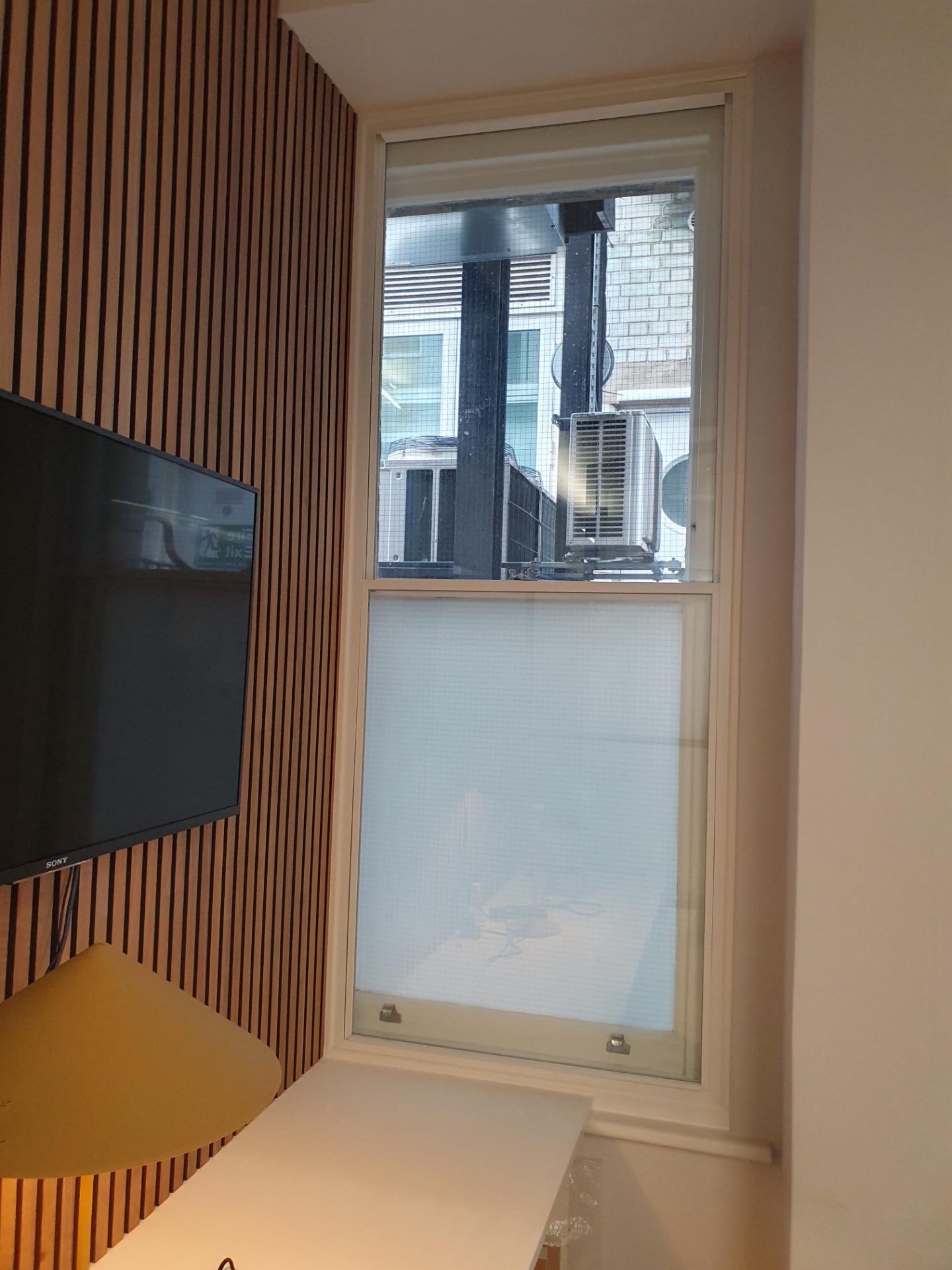 Vertical sliding secondary glazing installation showing technical implementation